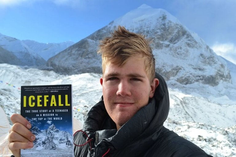 Alex Staniforth holding Icefall book in front of a mountain