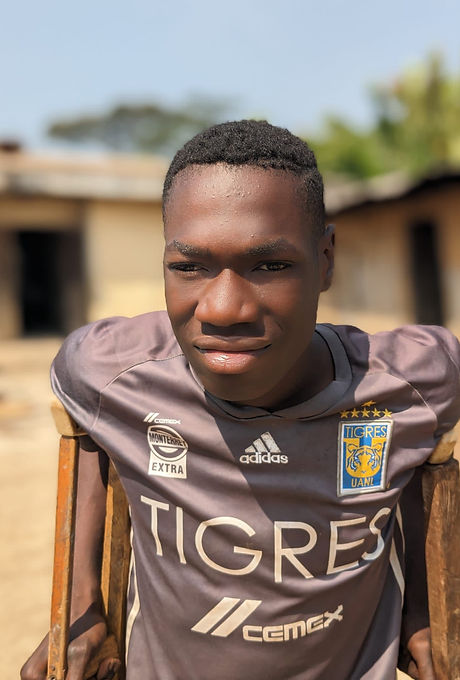 Young man with disability wearing a football shirt, an Afidi Handi Defi beneficiary in Cameroon