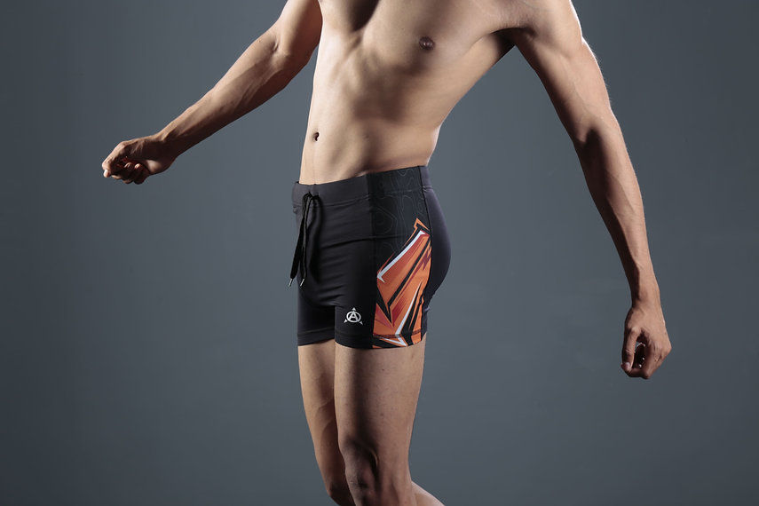 Men's black compression shorts with orange accents
