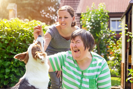 special-needs-female-with-female-carer-giving-treats-to-a-dog.jpeg