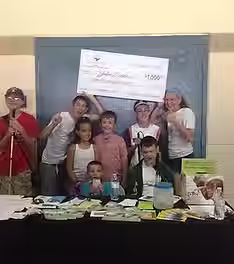 Another kids holding check with a few other kids.avif