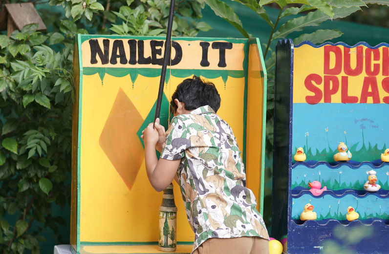 Child playing carnival-style game at wild animal birthday party in Bangalore