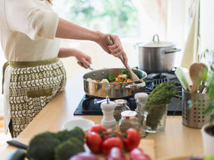 A woman stirs food in a pan. 