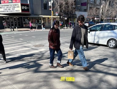 People looking at the guerrilla sidewalk stencil and sticker for dating app Bumble in New York City