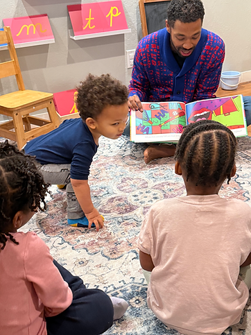 Children sitting in a circle during reading time at Oakland Community Montessori School, a preschool and daycare serving children 18 months to 5 years old in Oakland and the East Bay