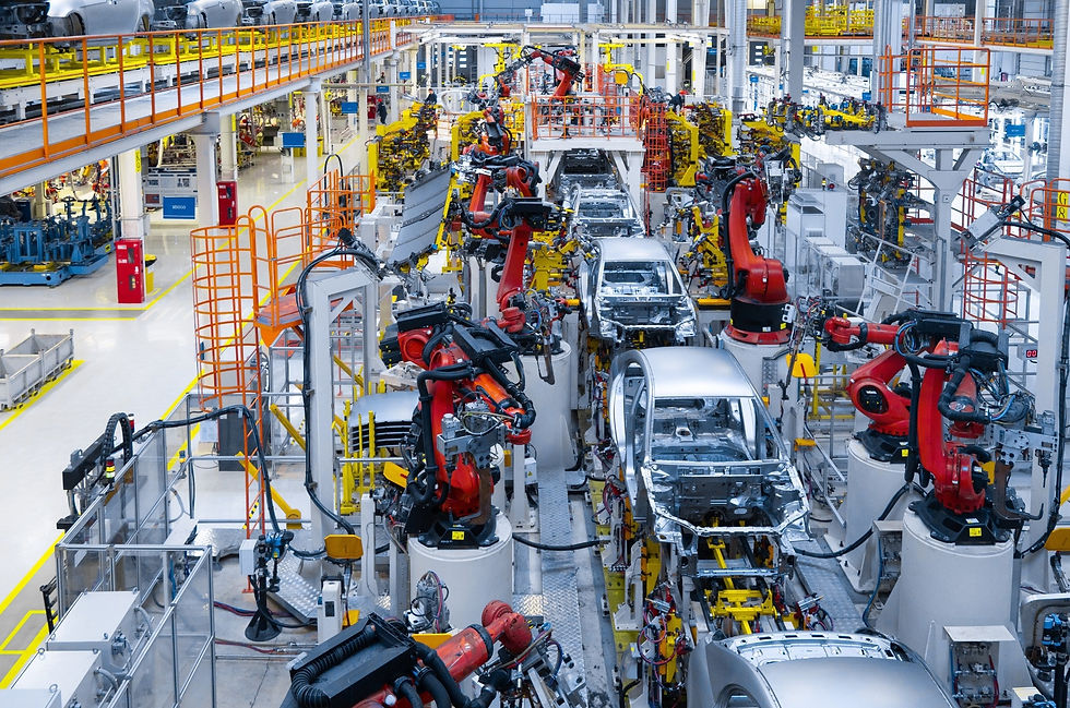 Línea de producción automotriz con robots industriales ensamblando vehículos en una planta de manufactura avanzada.