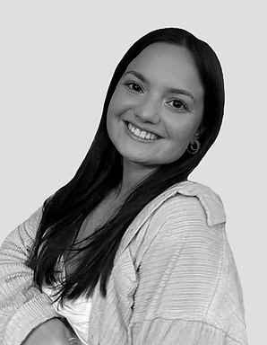 Black and white photo of Maria Delle Monache, smiling warmly. Trained in various styles of dance, Maria brings her passion and expertise to students at Peak Dance Company, inspiring creativity and growth in our Niagara-on-the-Lake studio.