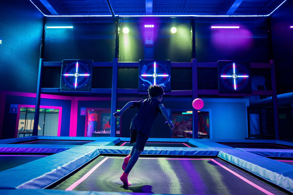 Boy on trampoline kicking ball at interactive targets