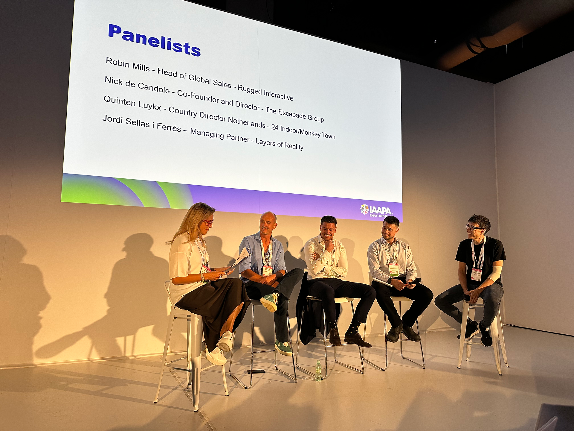 Group of people sat on stools at panel talk