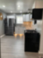 Sleek black appliances complement white cabinetry in kitchen.