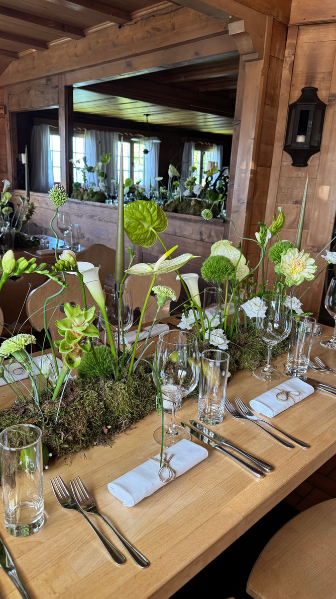 Green arrangement with calla lilies, the mirror behind it