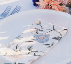 Place setting with coral blooms and a soft pink glass