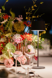 Detailaufnahme einer modernen floralen Tischdekoration mit Anthurien, Dahlien und feinen Sommerblüten, GAEA Design florales Eventdesign Schweiz.