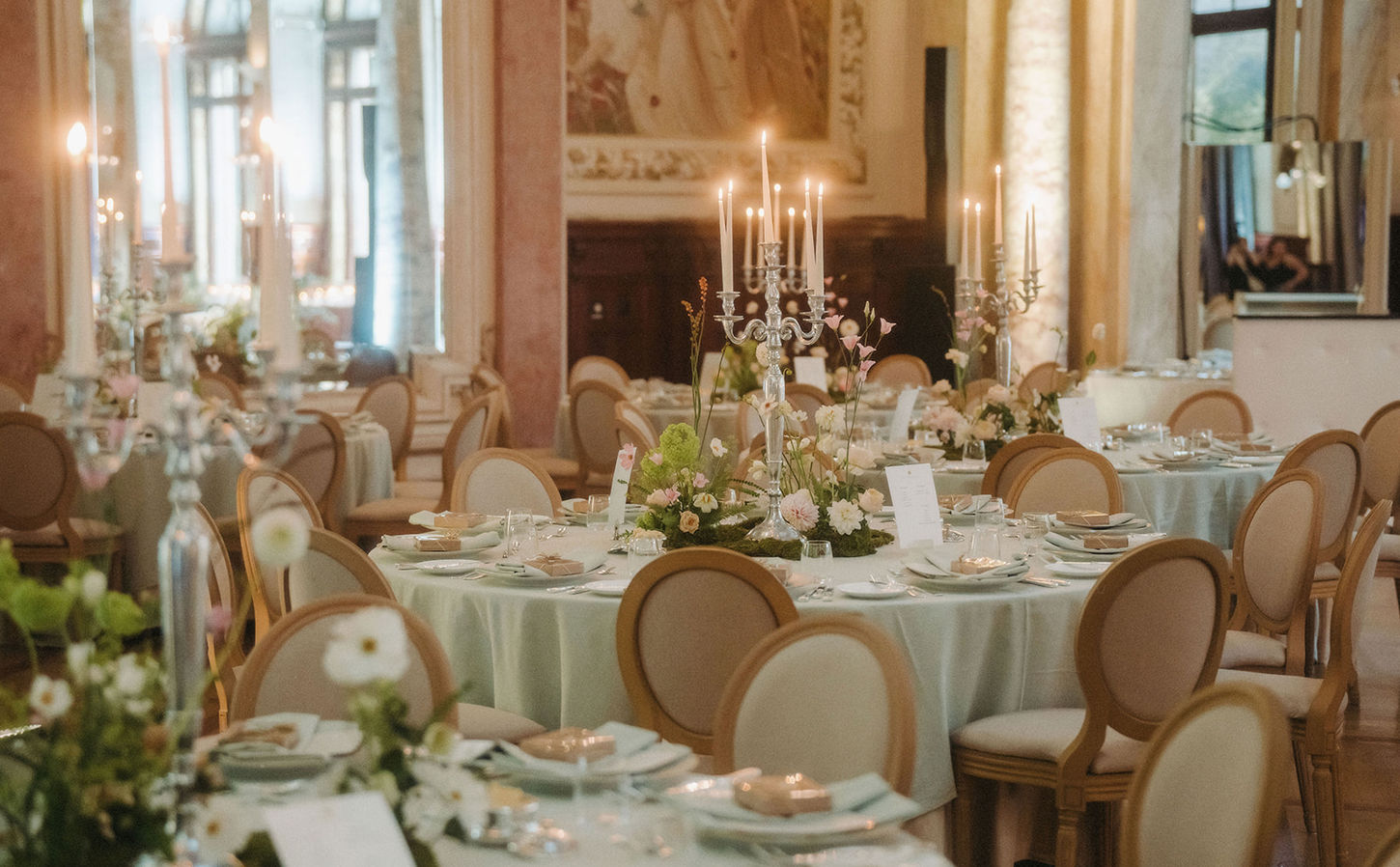 Ballroom set for dinner with white florals and candlelight