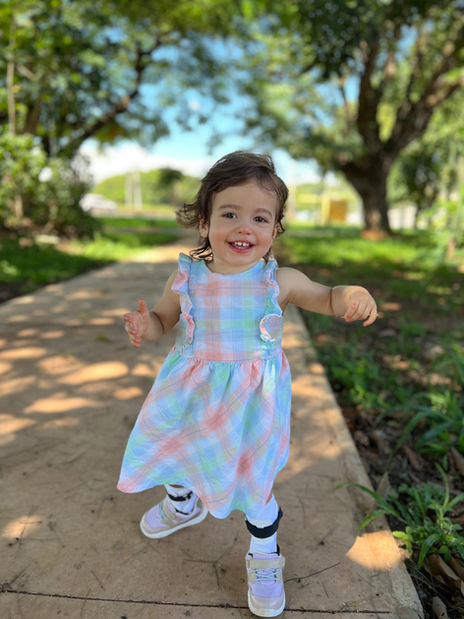 Eloise is a joyful, curious, and loving 2-year-old who brings so much happiness to everyone around her. Her family says life with Eloise has been beautifully transformative, teaching them that love comes in many forms. Through her, they've learned to celebrate every milestone, embrace life's little victories, and see the world through a different lens. She has made her family more compassionate, patient, and intentional, while showing them just how resilient they can be together.
One of Eloise's favorite things is food! She's an adventurous eater who loves fresh fruit like berries, kiwi, bananas, and mandarins, along with crunchy vegetables such as carrots and bell peppers. She enjoys family walks to the playground, where you'll usually find her smiling on the swings, racing to the slide, or splashing in the water. At home, she loves looking through books, playing with her Tiny People dolls, and spending time with her favorite person—her inseparable twin brother, Leone. Together, they fill their home with laughter, especially while dancing to The Wheels on the Bus and Rock-a-bye Your Bear.
Eloise was diagnosed with DLG4 SHINE Syndrome at 22 months after hypotonia was noticed shortly after birth. She works hard every day to overcome global developmental delays and attends occupational, physical, and speech therapy each week. She wears adaptive leg braces to support her growing confidence as she learns to walk. Eloise also navigates sensory processing challenges, gastroparesis, reflux, motion sickness, and occasional sleep difficulties, but her family has found routines and strategies that help her thrive.
Eloise reminds us that progress isn't measured by the size of a milestone, but by the determination behind every step. Her bright smile, adventurous spirit, and loving bond with her family make her a truly SHINEing Star.