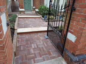 Travertine steps with retaining oak sleepers.