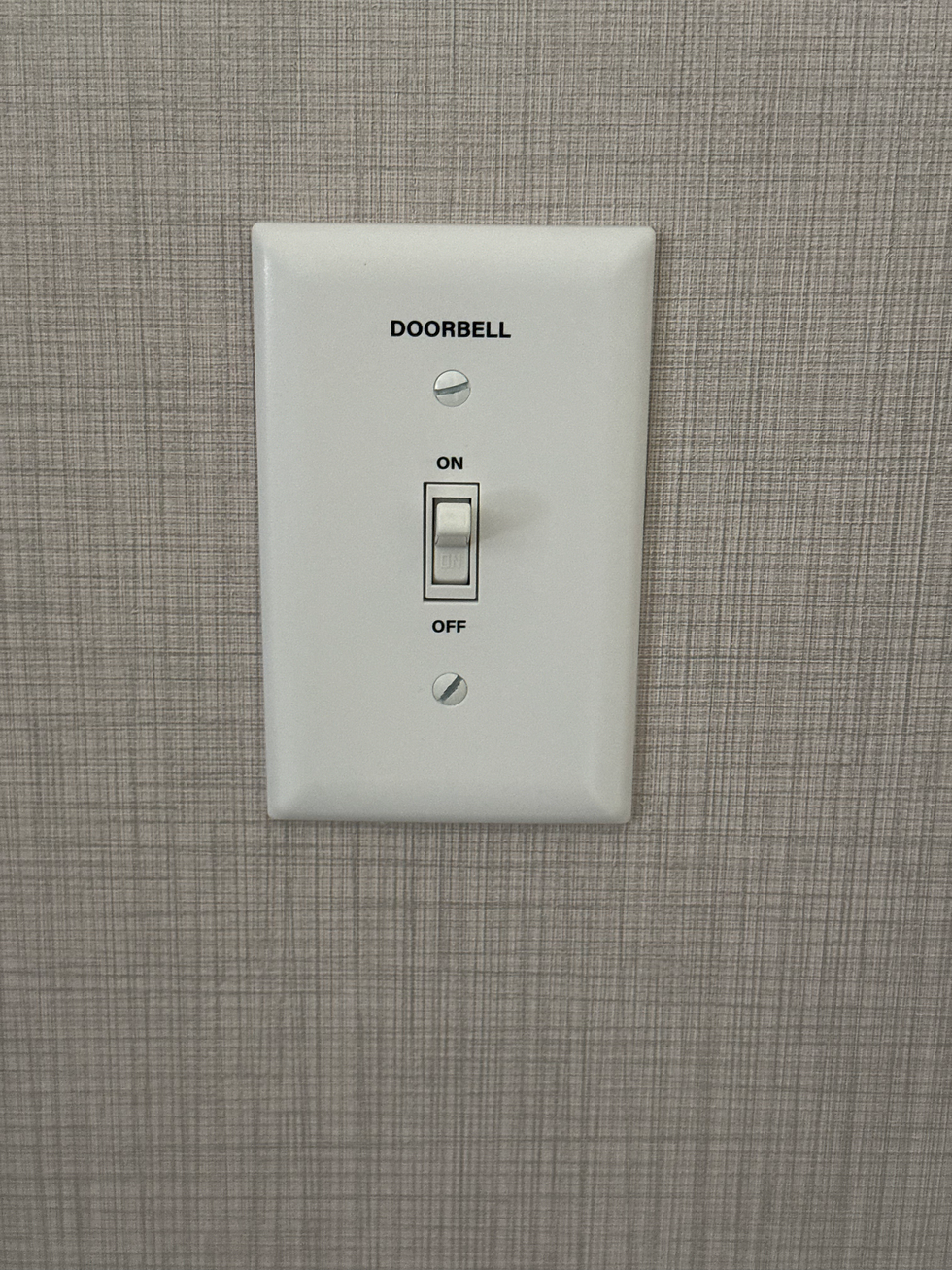 Light switch cover with the word DOORBELL printed.