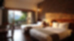 Cozy hotel room featuring a harmonious blend of textures, including a rustic brick wall and inviting wooden furnishings, inviting guests to relax and enjoy the scenic outdoor view.
