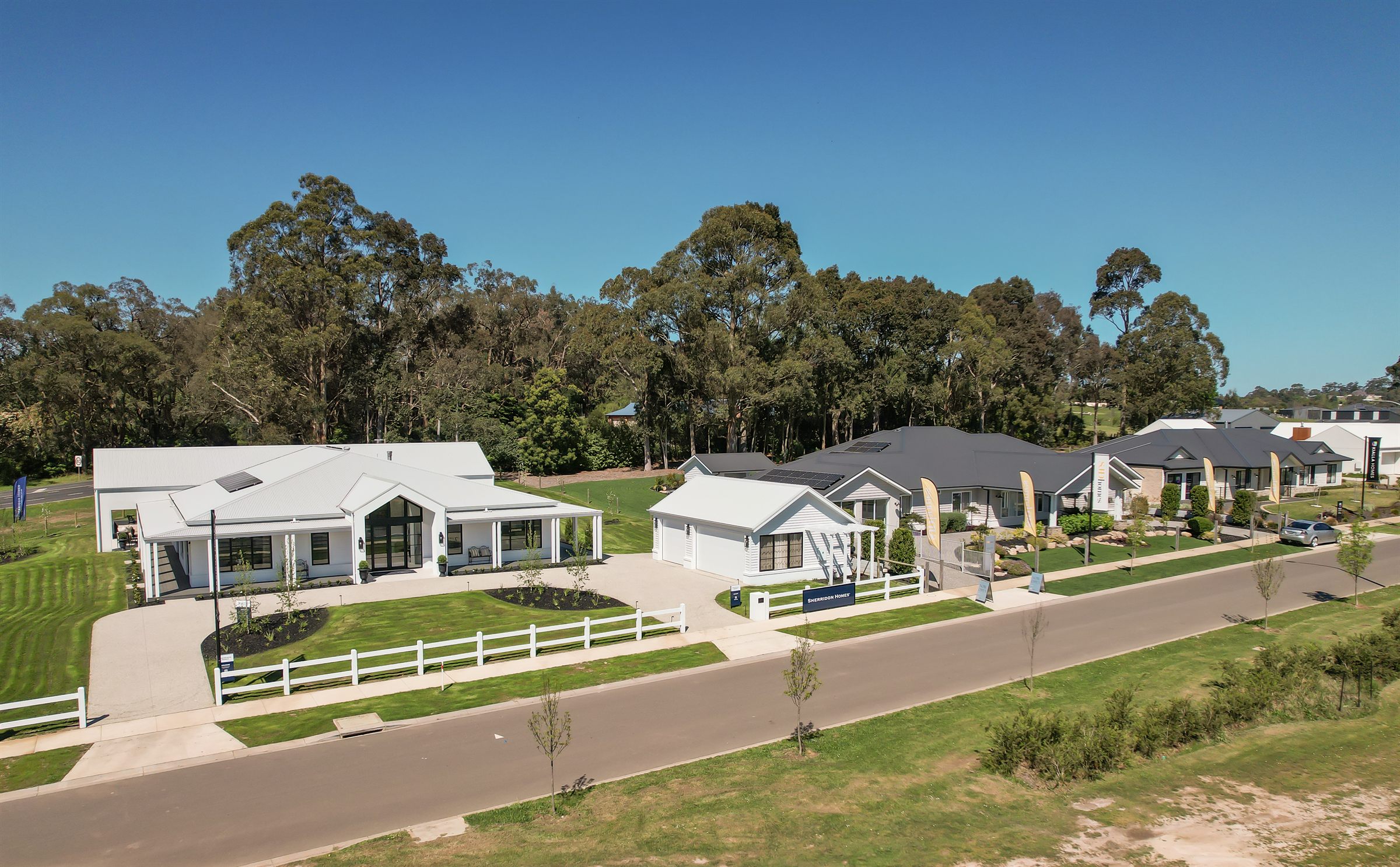 Display homes with gardens and picket fences at The Fairways, Drouin