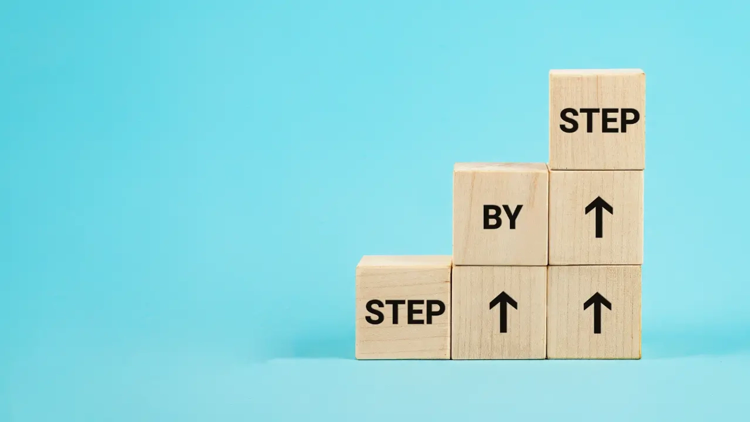 Wooden blocks showing the words "step by step."