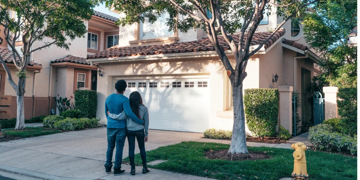 Happy homeowners (with their back against the camera) looking at their Florida carpenter ant-free home