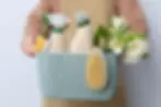 A person carrying a basket full of cleaning materials.