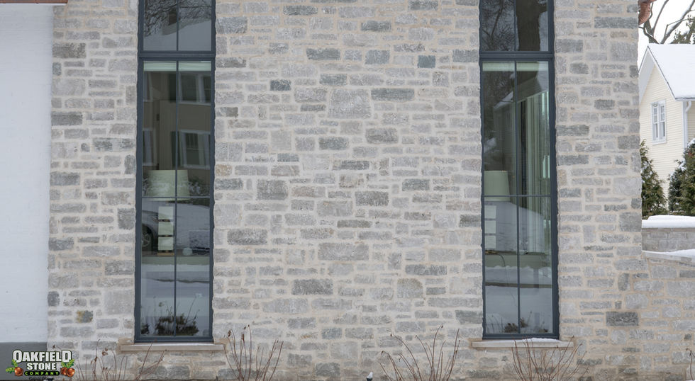 Natural building stone veneer quarried by Oakfield Stone Company, this dolomitic Limestone is known for its high compressive strength and longevity. Available in full-bed depth and natural thin stone veneer. White, Gray, Silver, Blue color tones make up this 100% machine cut splitface Natural Stone blend. Perfect for Exterior or Interior stone masonry applications.