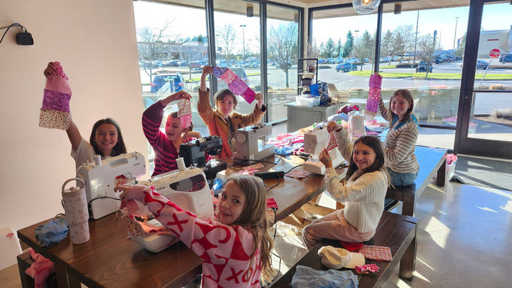 A young student learning hands-on sewing skills in Burlington studio