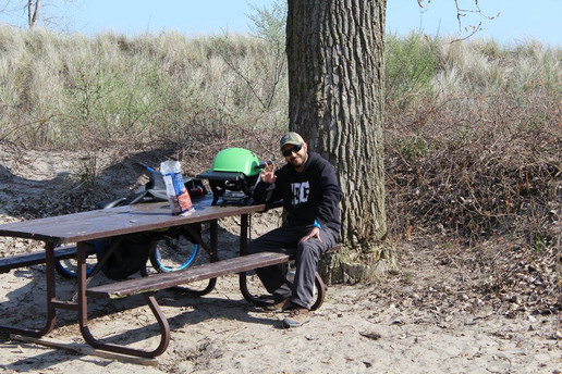 Kevin sitting at the picnic table with Weber Q Grill