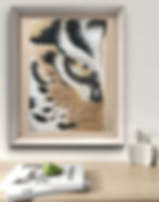 A mockup of a Tiger's eye Artwork framed and hung up on a wall