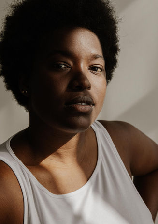 black African woman actor portrait beauty commercial white top black jeans studio light Berlin Germany