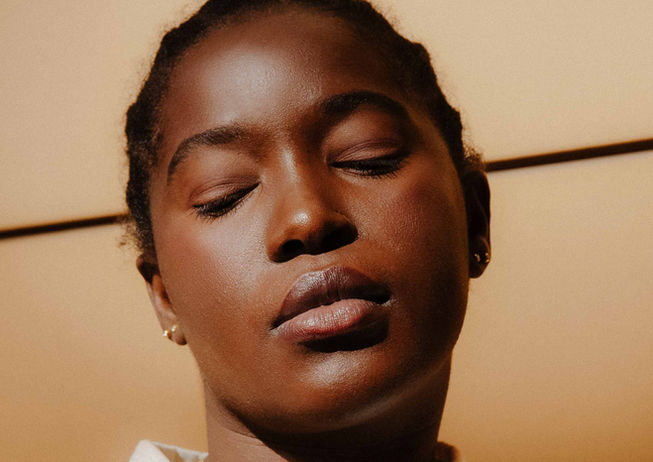 black African woman make up portrait beauty commercial jewellery pop outfit orange suite lady boss Berlin Germany