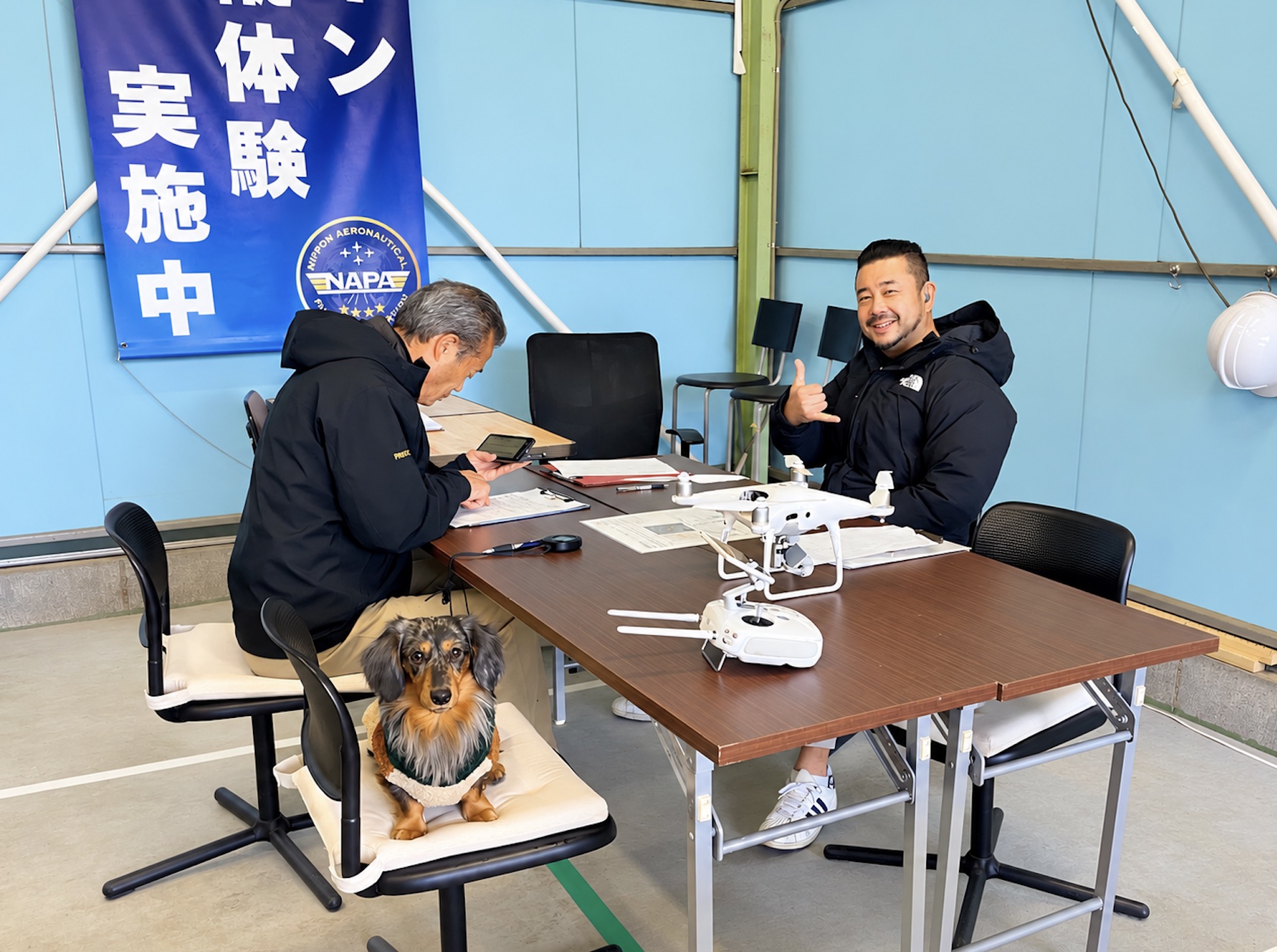 NAPAドローンアカデミーの国家資格講習で受講者と講師が機体を確認している様子