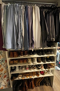 Organized Men's Closet with shirts and pants hanging, color coordinated rainbow order and shoe shelves with shoes lined up neatly
