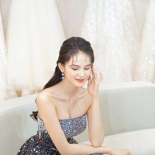 váy cưới đen đính đá - cô dâu tạo dáng ngồi đưa tay lên tai - phong cách Hàn Quốc