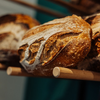 Pain artisanal posé sur un étalage de boulangerie, exemple de photographie gastronomique pour valoriser les produits frais.