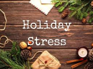 Wooden table with holiday decor: pine branches, pinecones, gift, candle. Text "Holiday Stress" in center. Warm, rustic atmosphere.