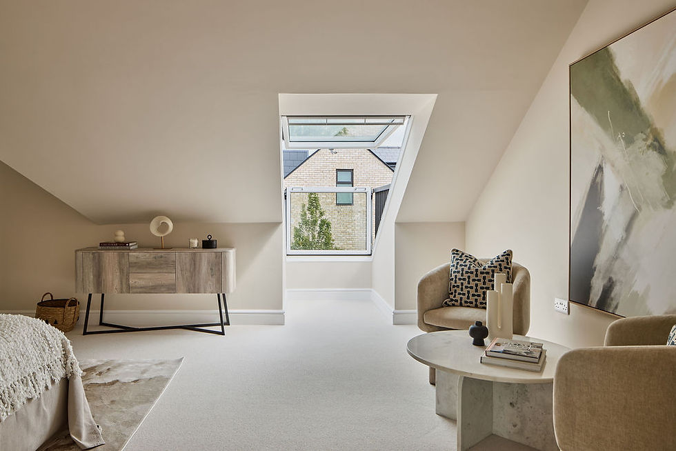 Modern attic room with beige tones, featuring a window view, abstract art, cozy chairs, a round table, and a wood sideboard with decor.