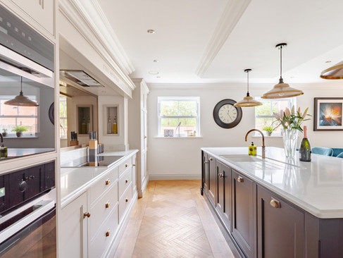 Spacious traditional kitchen with dual islands, integrated appliances, brass fittings and bright windows overlooking the garden.
