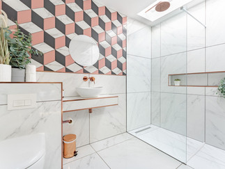 Modern bathroom with geometric feature wall tiles, floating vanity unit, vessel basin and spacious walk-in shower with glass enclosure.
