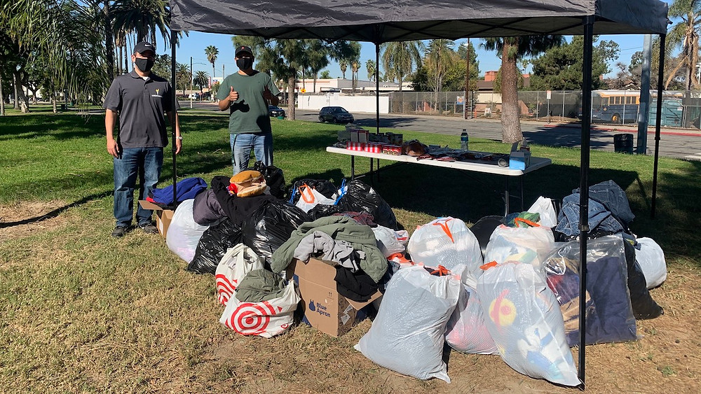 LPOC Chairman David Naranjo and a volunteer with the clothes donated by attendees.