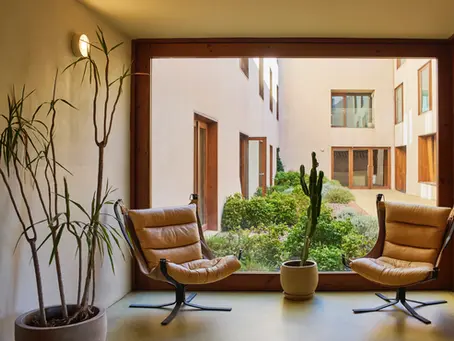 Cadeirões junto a janela com vista para jardim interno