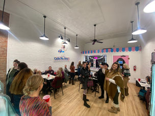 women gathered for a networking event inside of a cake shop