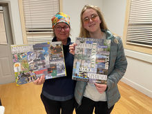 two women holding vision boards they created