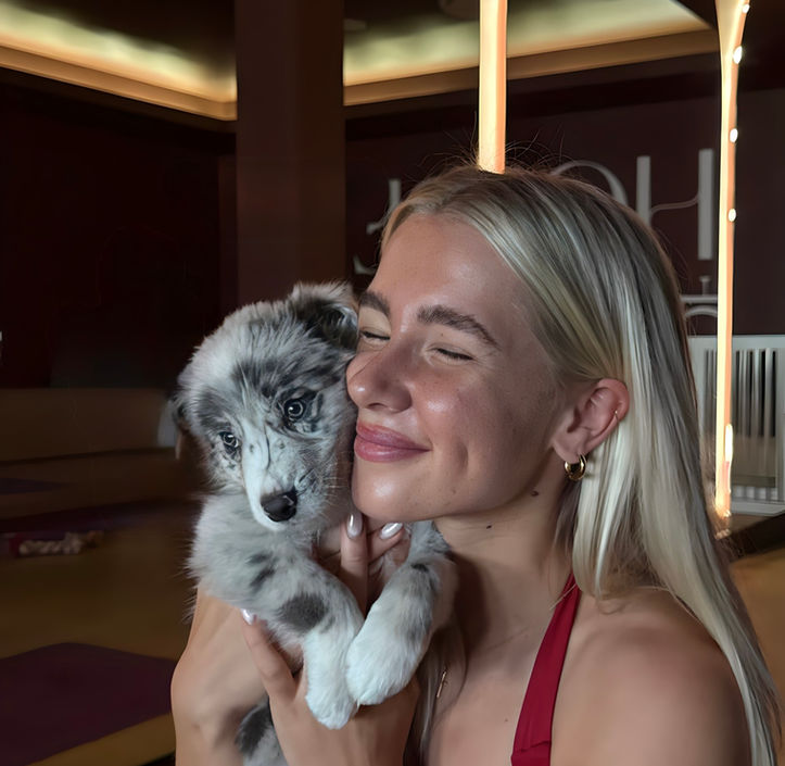Participant holding a Border Collie during a Puppy Yoga Session at House of Motion, Gold Coast