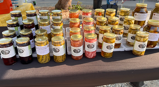 Farmer's Market stand with rows of beautiful jars full of pickled vegetables