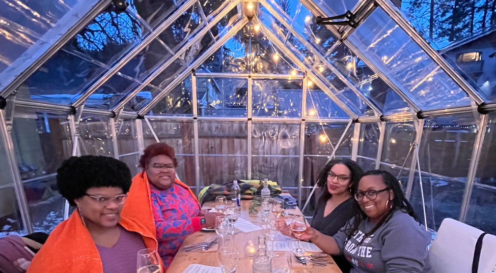 Four women eating dinner outdoors.