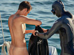 Below the Surface: Nothing Worn Beneath. Scuba divers removing their wetsuits after a dive, revealing bare skin beneath. A photo series by Stefan Pinto.