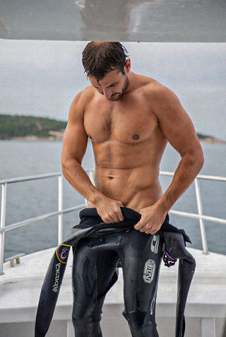 Below the Surface: Nothing Worn Beneath. Scuba divers removing their wetsuits after a dive, revealing bare skin beneath. A photo series by Stefan Pinto.