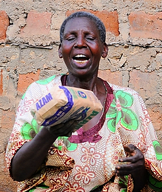 Lady holding bread from Christmas Hamper in Ugandan village
